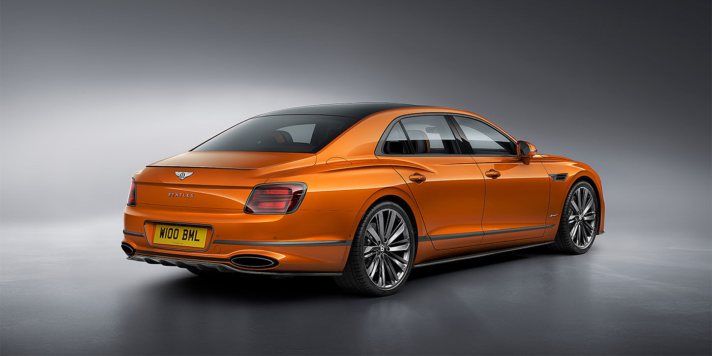 Bentley Athens Bentley Flying Spur Speed in Orange Flame colour rear view, featuring Bentley insignia and enhanced exhaust muffler.