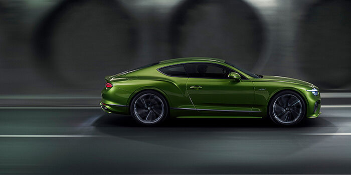  Bentley Athens Bentley Continental GT coupe in Tourmaline Green paint driving in profile on a dark road